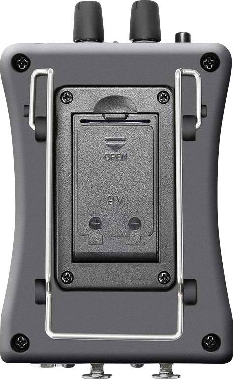 Portable audio device from the back, showing battery compartment with printed arrow and inscriptions 'OPEN' and '9V'.