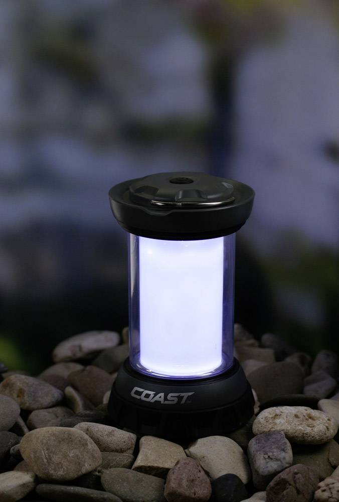 A portable lantern illuminates a bed of small stones, suitable for outdoor activities and camping.