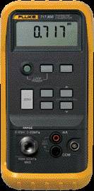 A digital pressure gauge with an orange casing shows the reading '0.717'. Operating buttons and connections are visible.