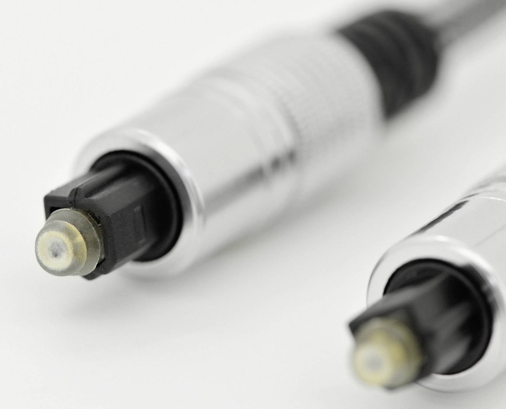Two silver optical audio cables with black connectors on a white background.
