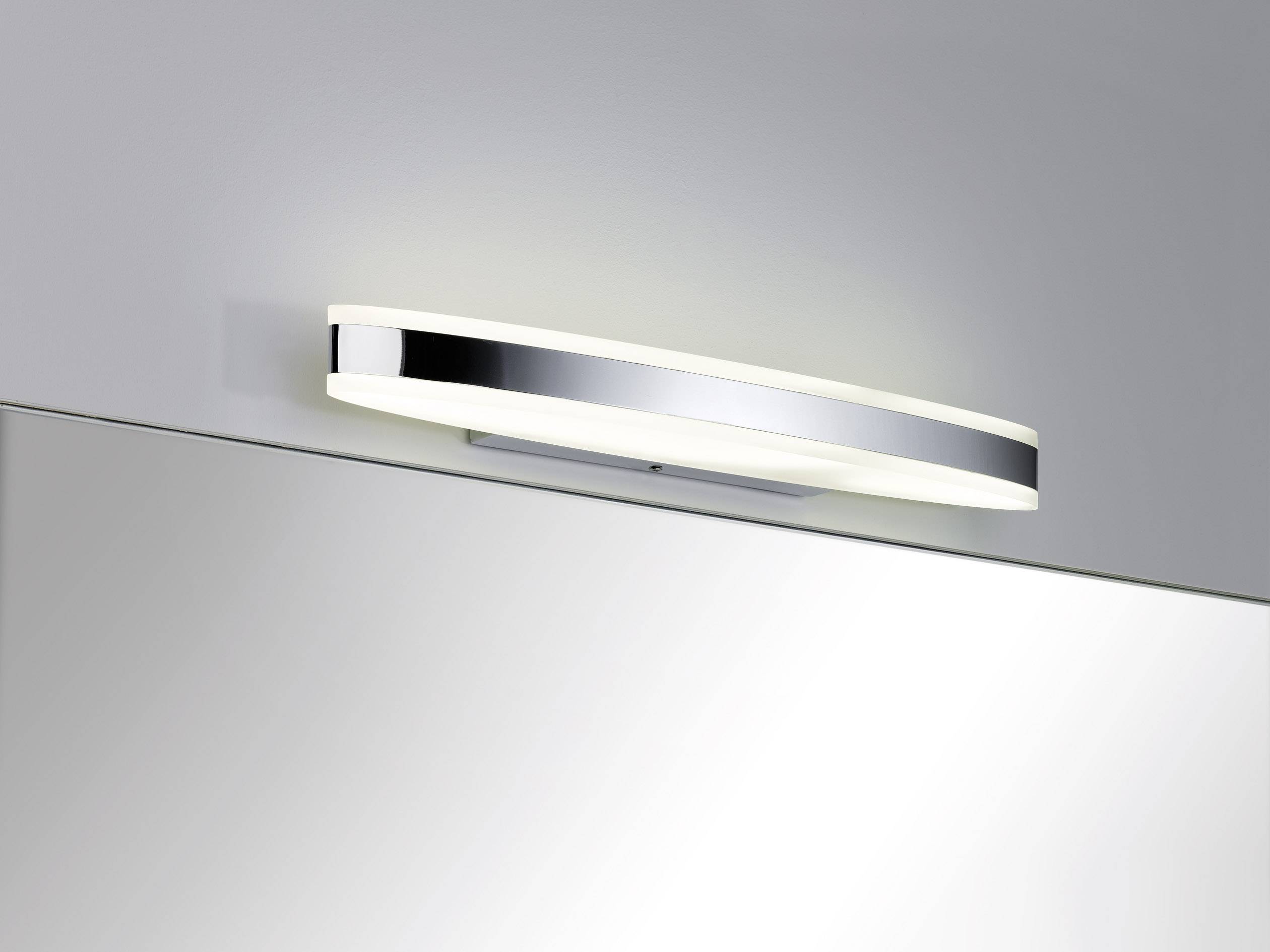 Wall light with a simple, modern design in chrome finish. Illuminates evenly and is mounted above a mirror.