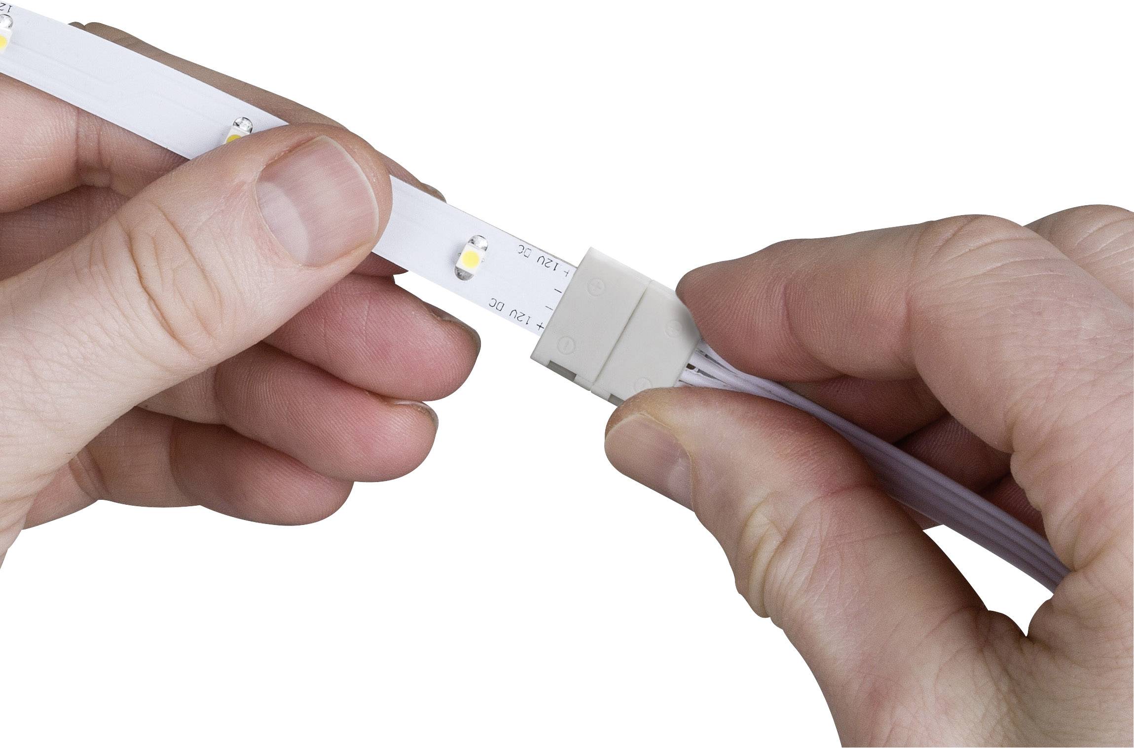 'Two hands connecting an LED strip with a white plug.'