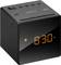 Black digital radio alarm clock displays '8:30'. The display glows orange. Buttons on top for volume and settings.