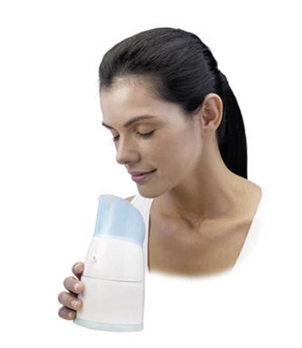 A woman is holding an inhaler, taking a deep breath and relaxing. It is used to alleviate respiratory conditions.