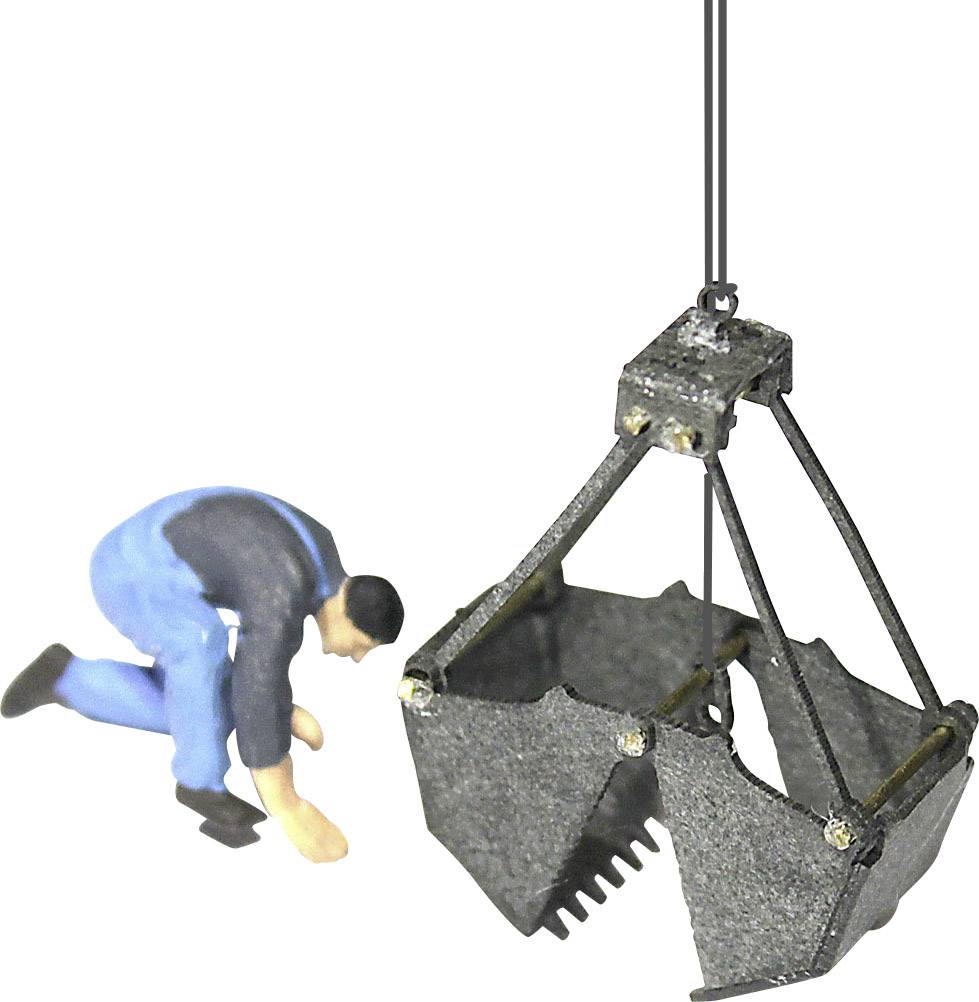 A figure in blue overalls leans beside a suspended crane or lifting mechanism.