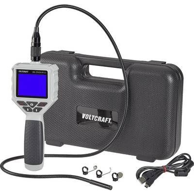 Endoscope camera with flexible cable, LCD display and control buttons. In the background, a black carrying case with 'Voltcraft'.