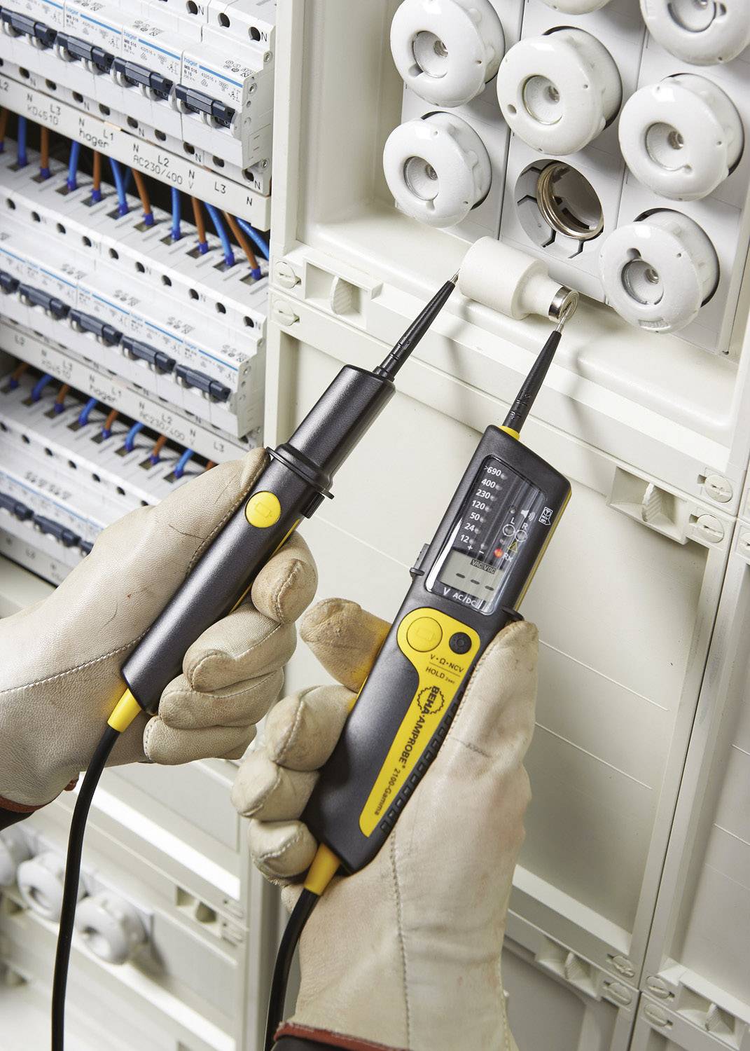 'A person is measuring the voltage in a fuse box using an electric testing device while wearing insulated gloves.'