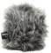 A grey, fluffy windshield for microphones with a small, black label with white text on the side.