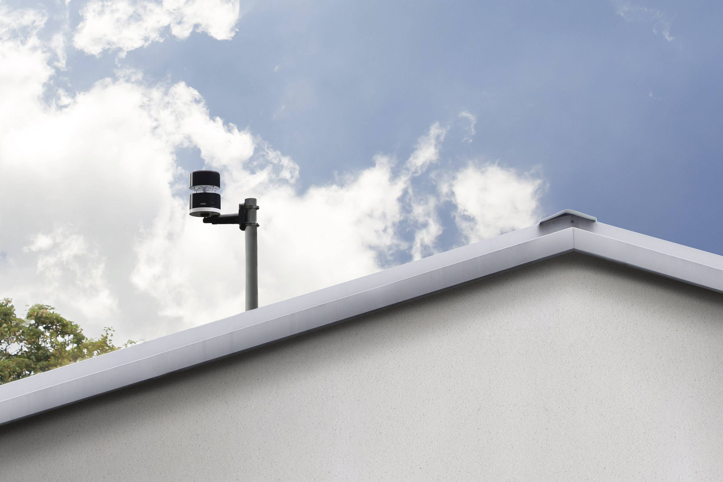 A camera is mounted on a roof. The sky is cloudy.