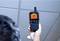 A person is holding a thermal imaging device pointed at a blanket. The display shows a colourful thermal representation.