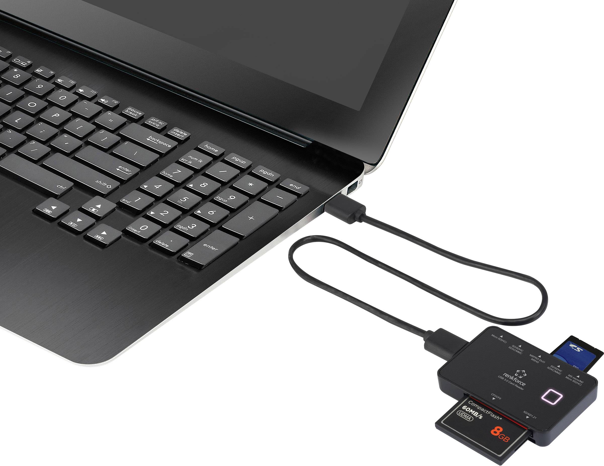 A laptop with a connected USB hub that reads SD cards and other storage media.