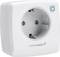 White smart plug by Homematic IP with a round socket and a blue button on the top right of the front panel.