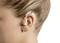 Person wearing a hearing aid behind their ear, viewed from the side profile.