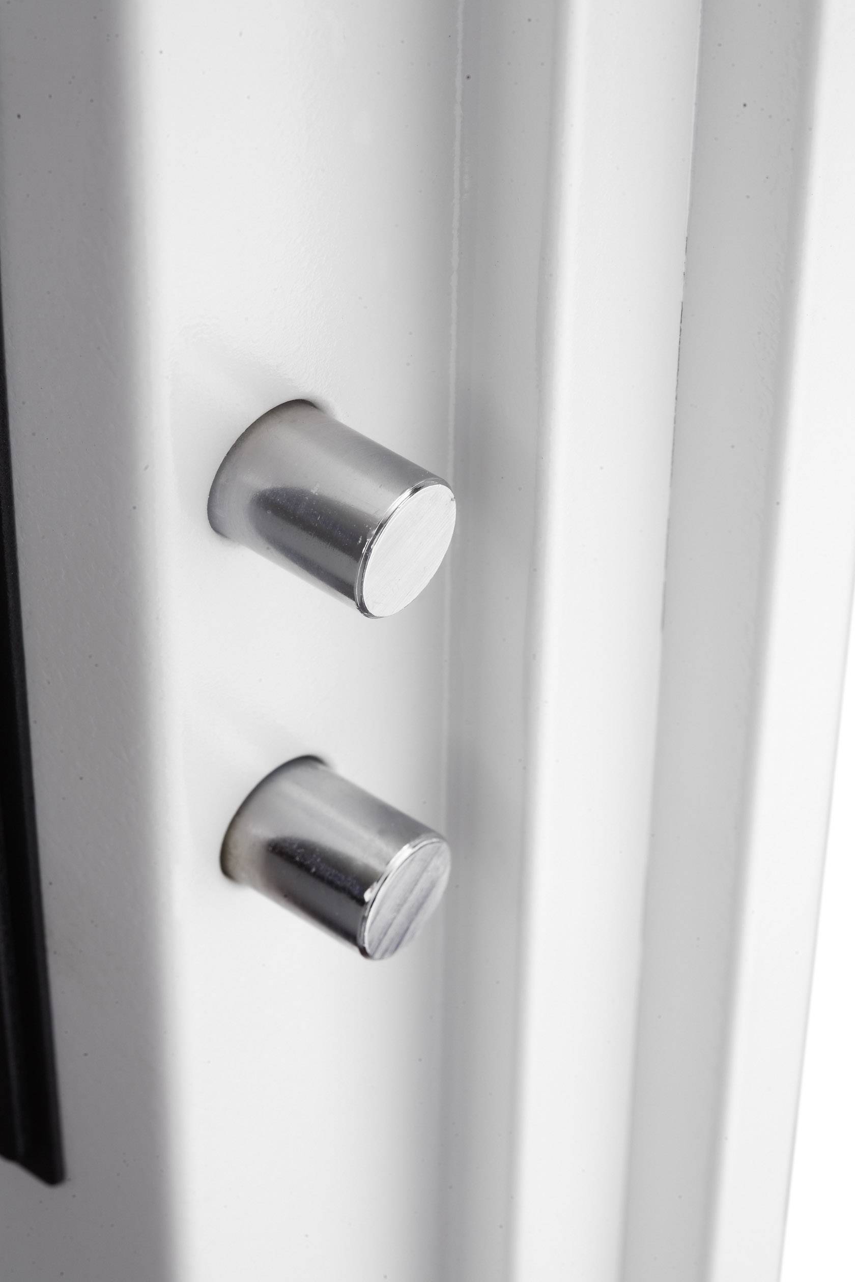 Close-up of two silver cylindrical door locks in a white door.