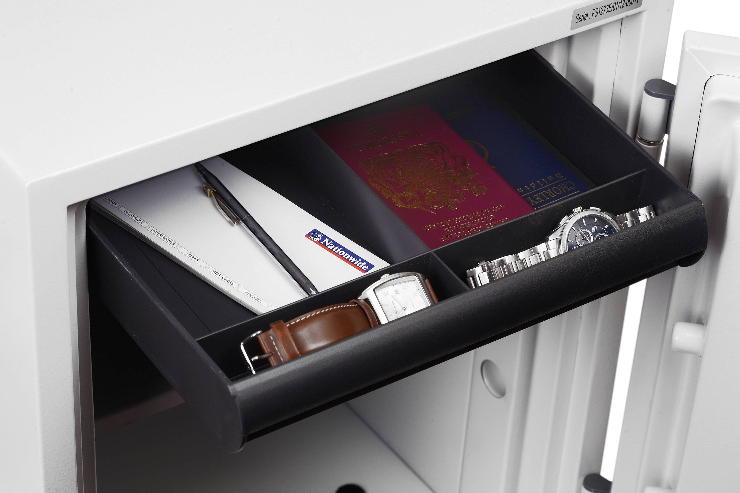 An open compartment in a safe containing a passport, watches, a pen and documents, conveying security and protection for valuables.