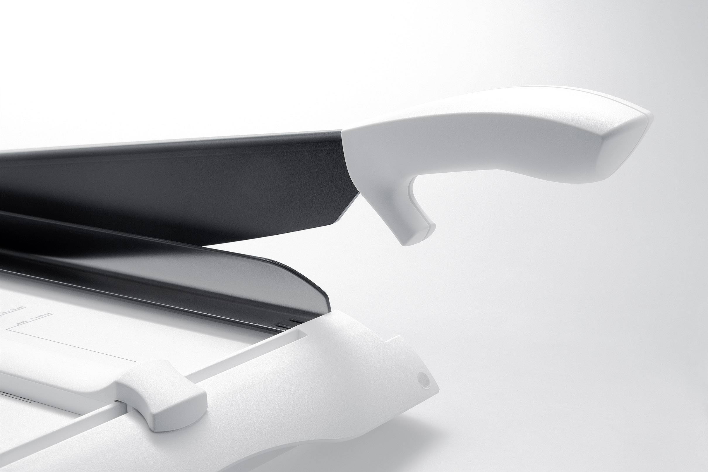 A closed and an open white chopping board with black details, representing modernity and functionality.