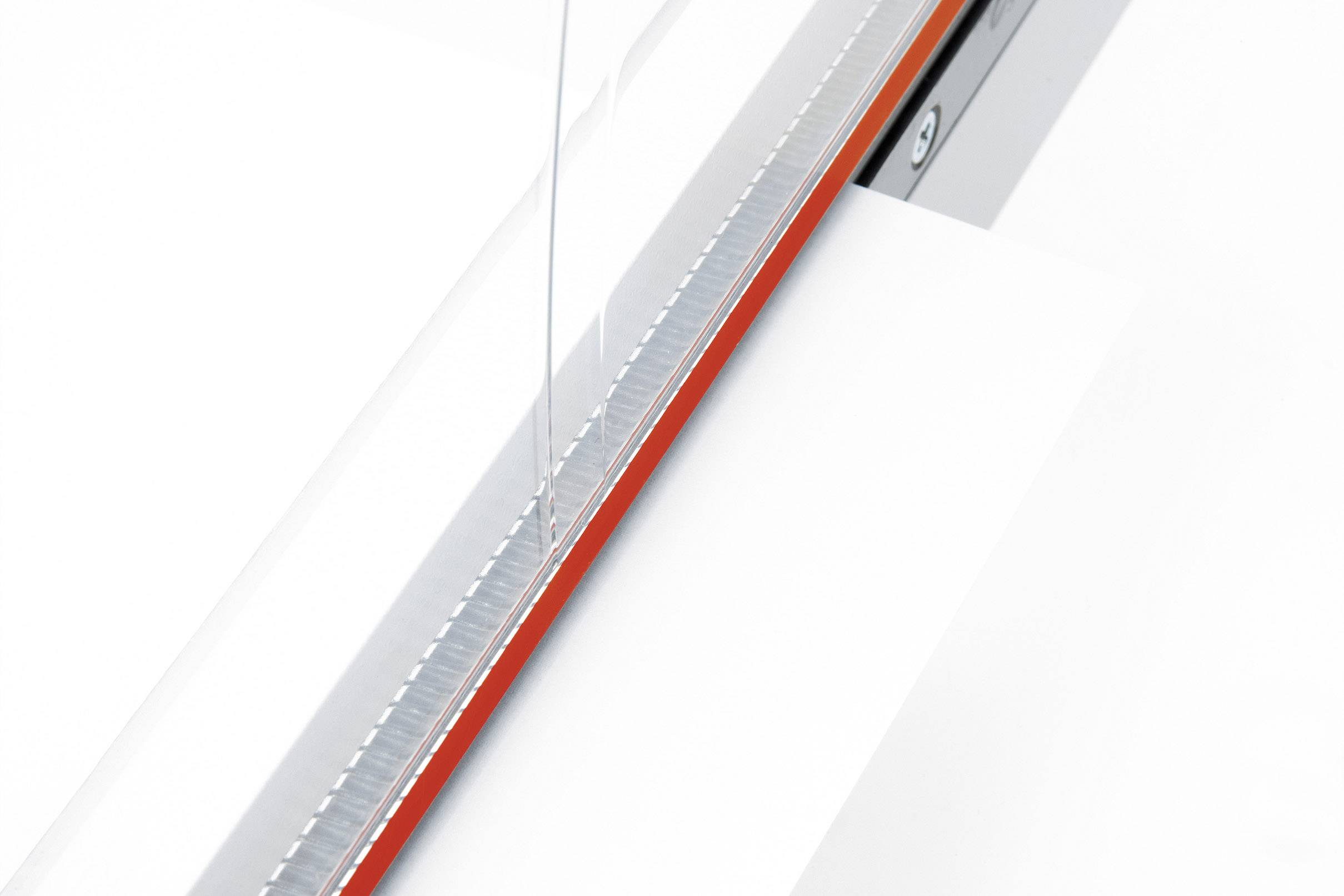 A bright room with a glass door featuring a narrow red stripe. The view focuses on the door mechanism.