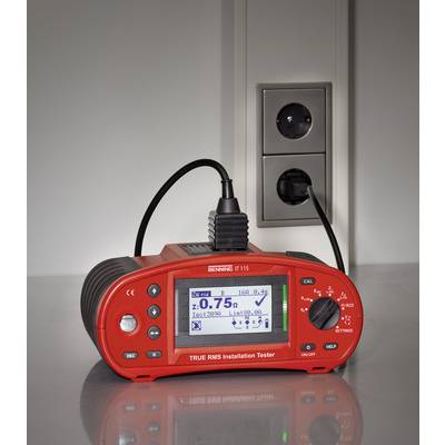 A red installation measuring device is plugged into a socket and displaying measurement readings on its display.