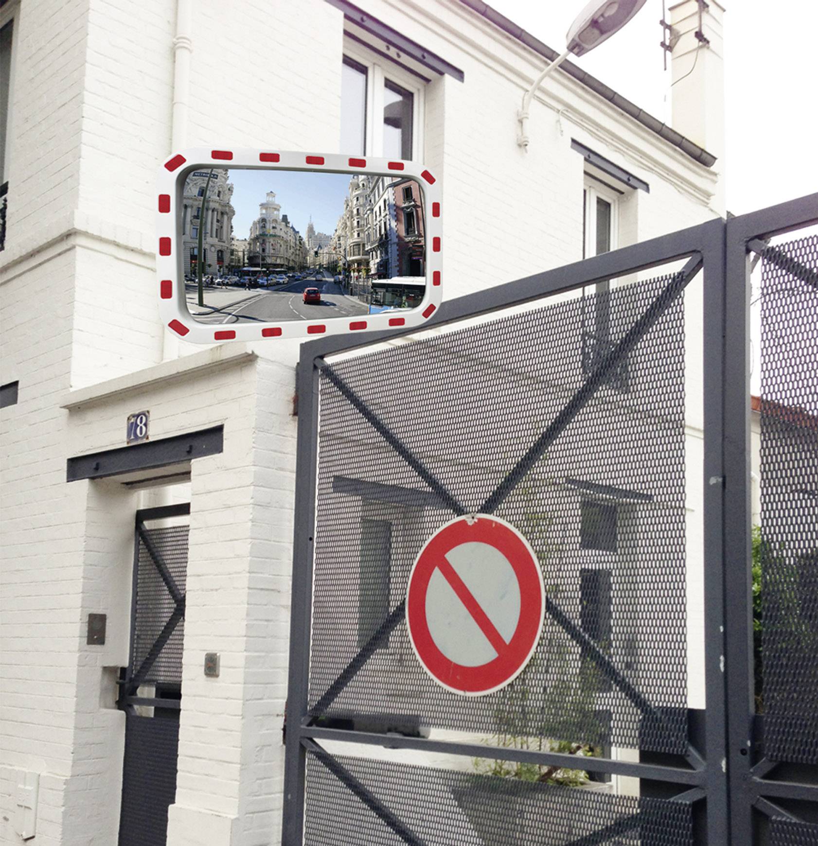 A large metal door with a 'No Entry' sign. In the reflection at the top left, a bustling city street can be seen.