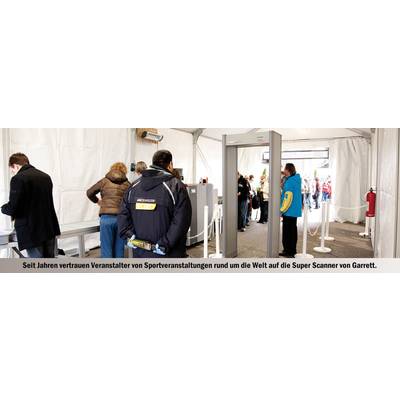 People pass through security control at a sporting event, while staff monitor the scanners.