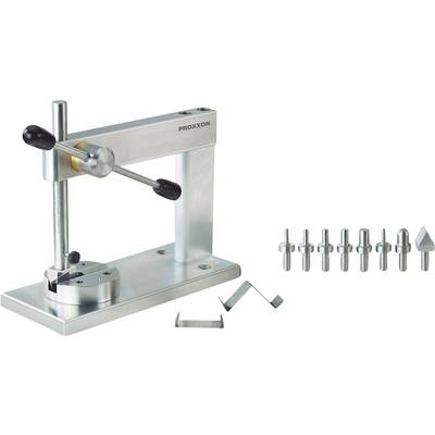 A watchmaker's press with a metal frame and lever handle, alongside nine different precision inserts and two metal components.