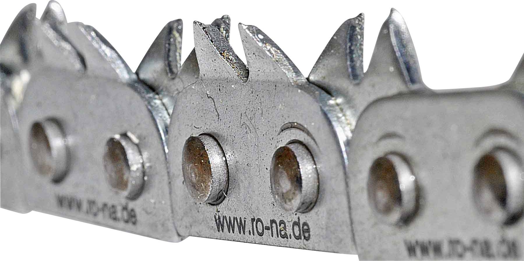 Individual chain links of a saw chain, photographed at an angle from the side. Teeth and rivets of the chain are visible.