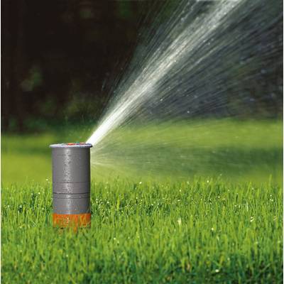 A lawn sprinkler on green grass, spraying water in an arc; background slightly blurred.