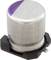 Small cylindrical aluminium electrolytic capacitor with purple marking on the top, mounted on a black base.
