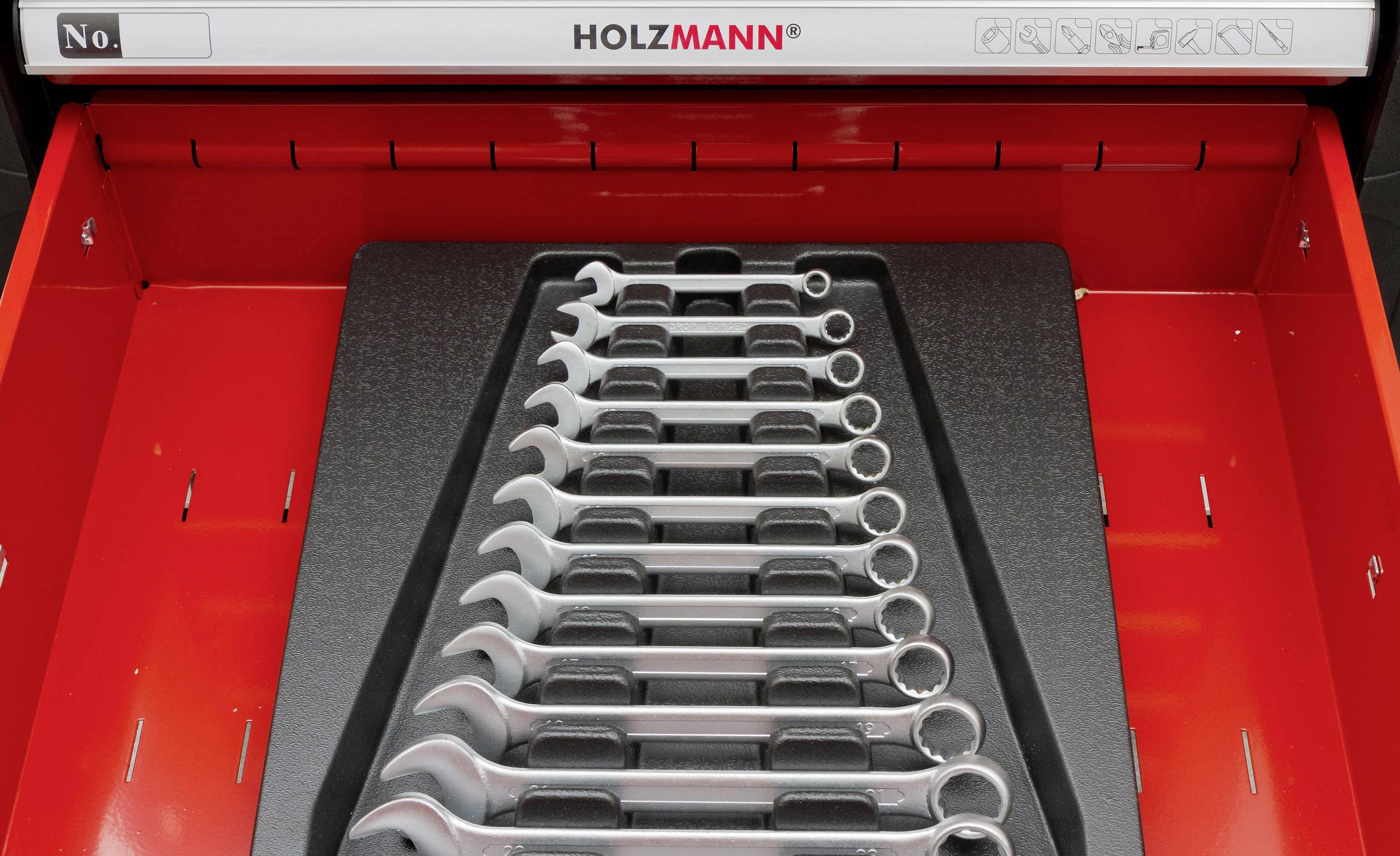 An open red toolbox drawer contains a set of eleven spanners, neatly arranged on a black insert.