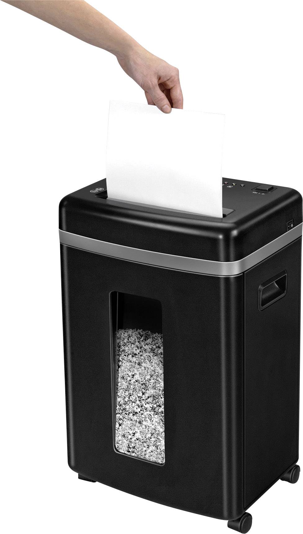 A hand places a white sheet of paper into a black paper shredder. Shredded paper can be seen inside.