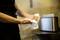 A person is drying their hands with a white paper towel in a kitchen. A shiny toaster stands in the background.