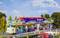 A detailed miniature representation of a lively fairground with a colourful dodgem ride. Visitors and vibrant lights can be seen.