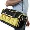 A person is holding a large, black and yellow tool bag with multiple compartments and tools, including pliers and a screwdriver.