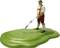 A small figure in traditional lederhosen stands on green ground and urinates a thin stream of water.