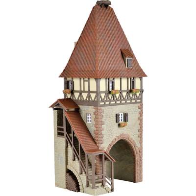 A mediaeval tower with half-timbered construction and a pointed roof. The tower has a wooden staircase on its external side and small windows with shutters.