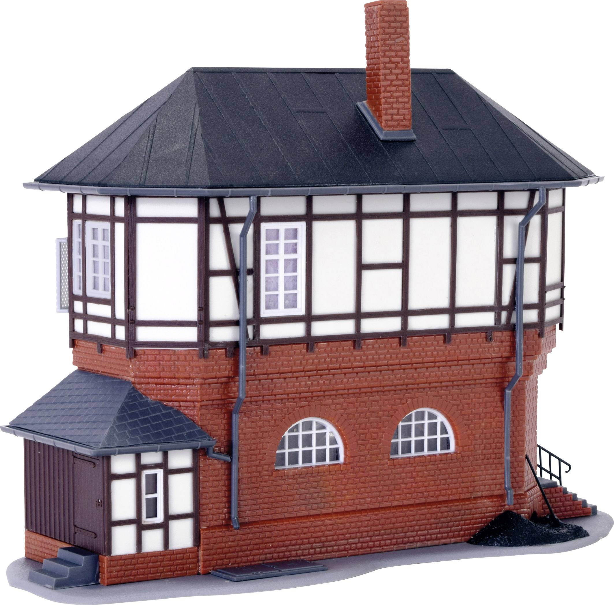 A miniature model of a half-timbered house with a red brick base, black roof, and small side extension.