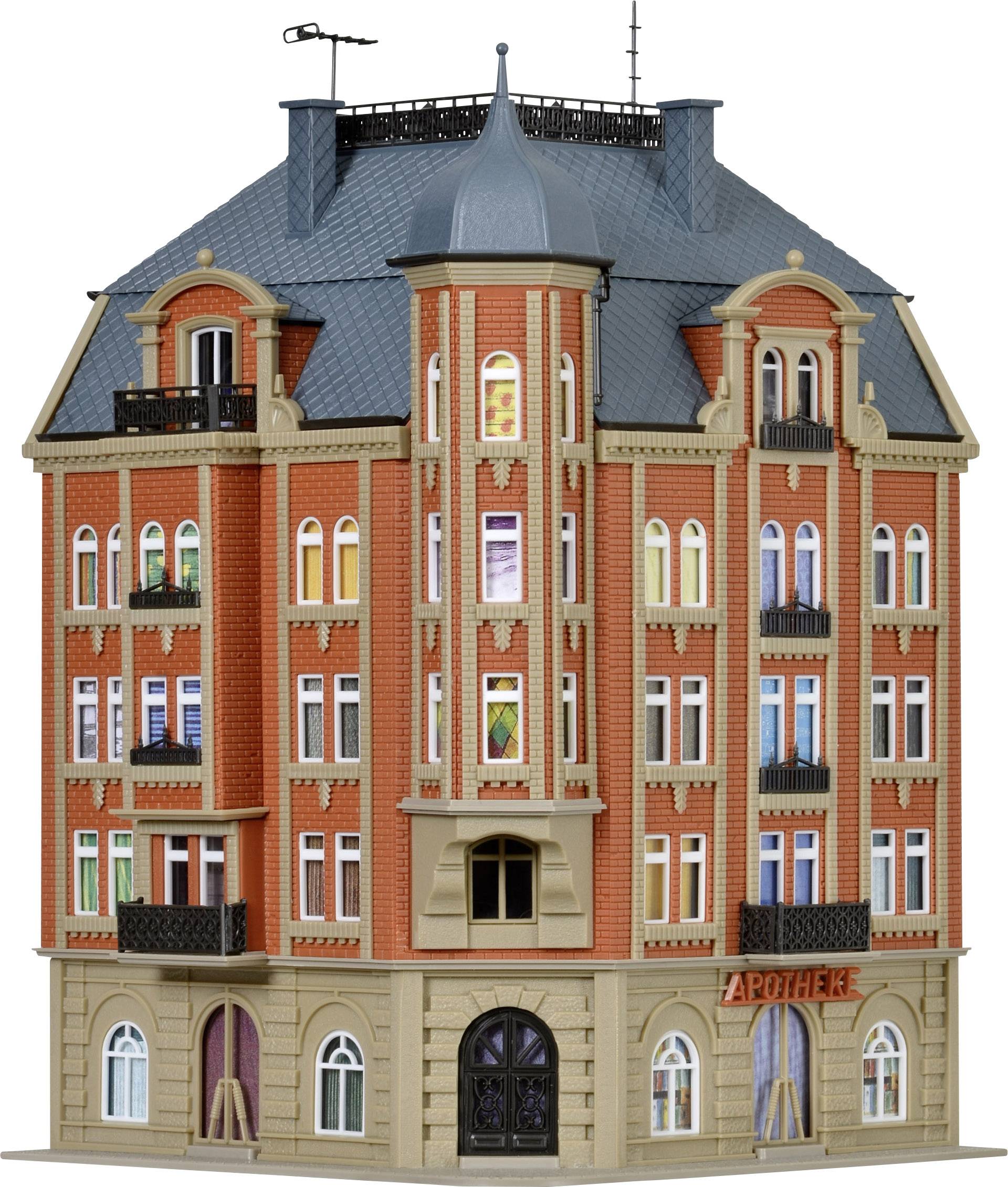 A multi-storey red brick building with a sign reading 'Chemist' above the entrance. There are numerous colourful windows and balconies.