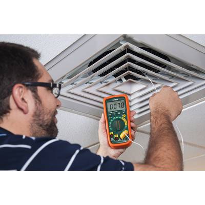 A person is measuring air quality near a ventilation grille with a measuring device showing 0.178.