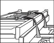 Load Securing: Two tie-down straps are fastening wooden boards to a vehicle roof. Crucial for safe transportation.