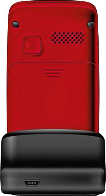 Back of a red flip mobile phone in a black charging station, showing speaker and camera lens.