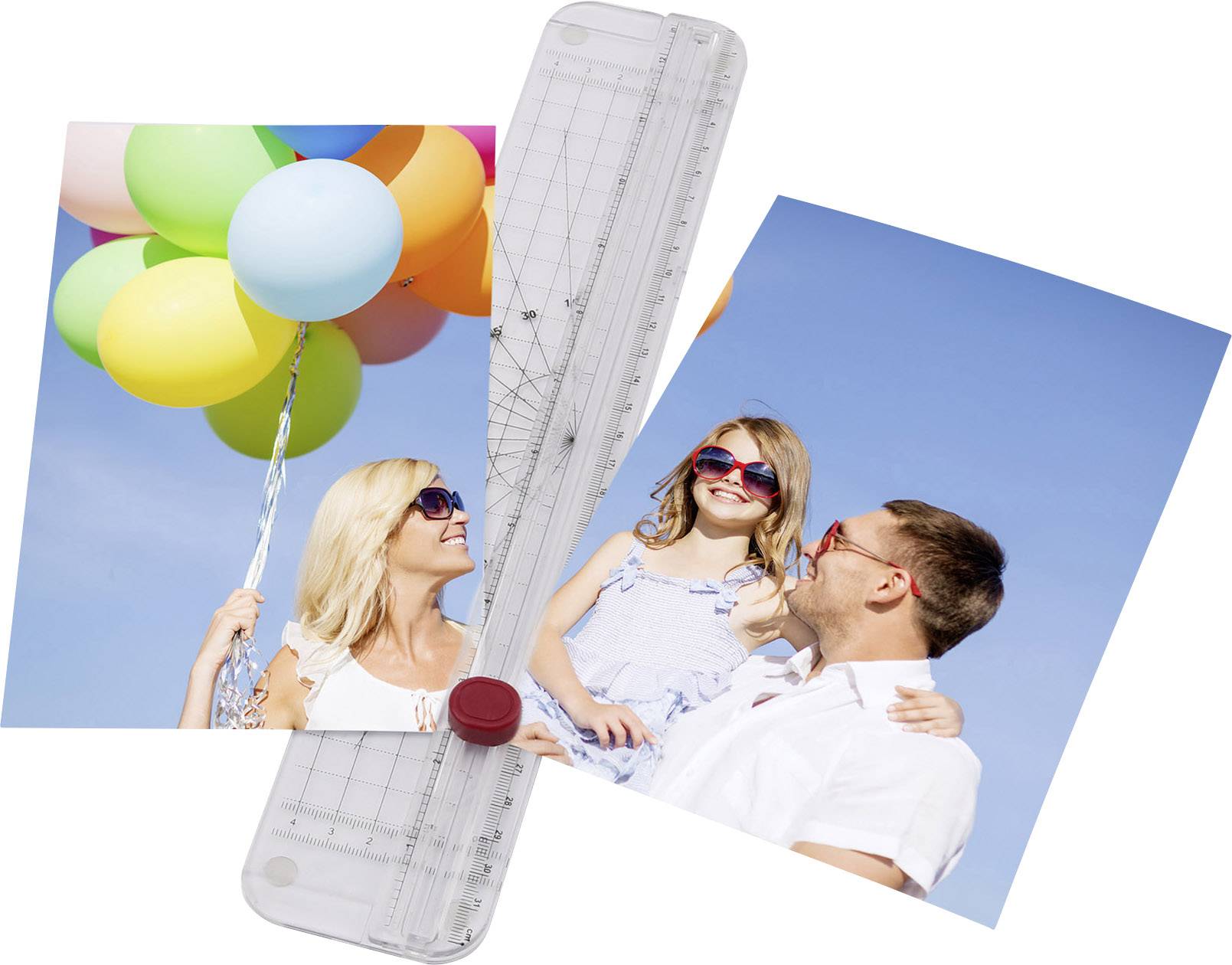 A paper cutter with a photo clamped in place shows happy people beneath colourful balloons in sunny weather.
