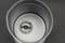 A metal gear wheel is situated within a cylindrical grey metal structure. The environment appears industrial and mechanical.
