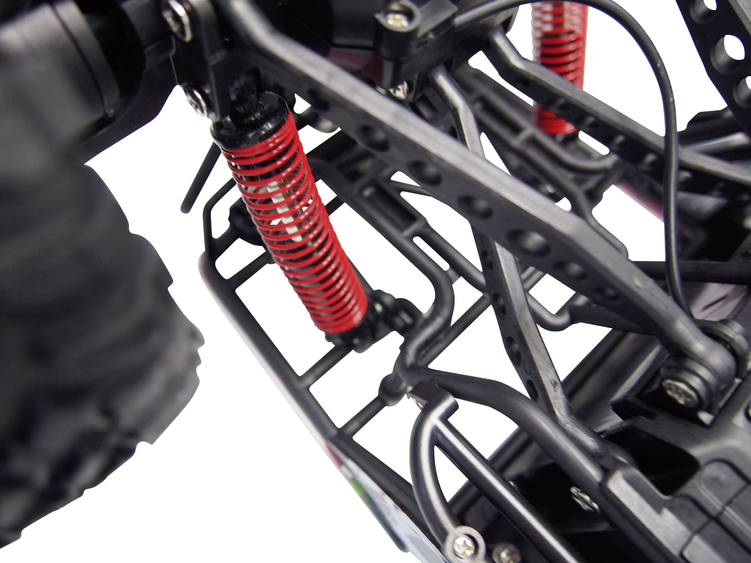 Close-up of a black metal frame with red shock absorbers, likely from a remote-controlled car or model vehicle.