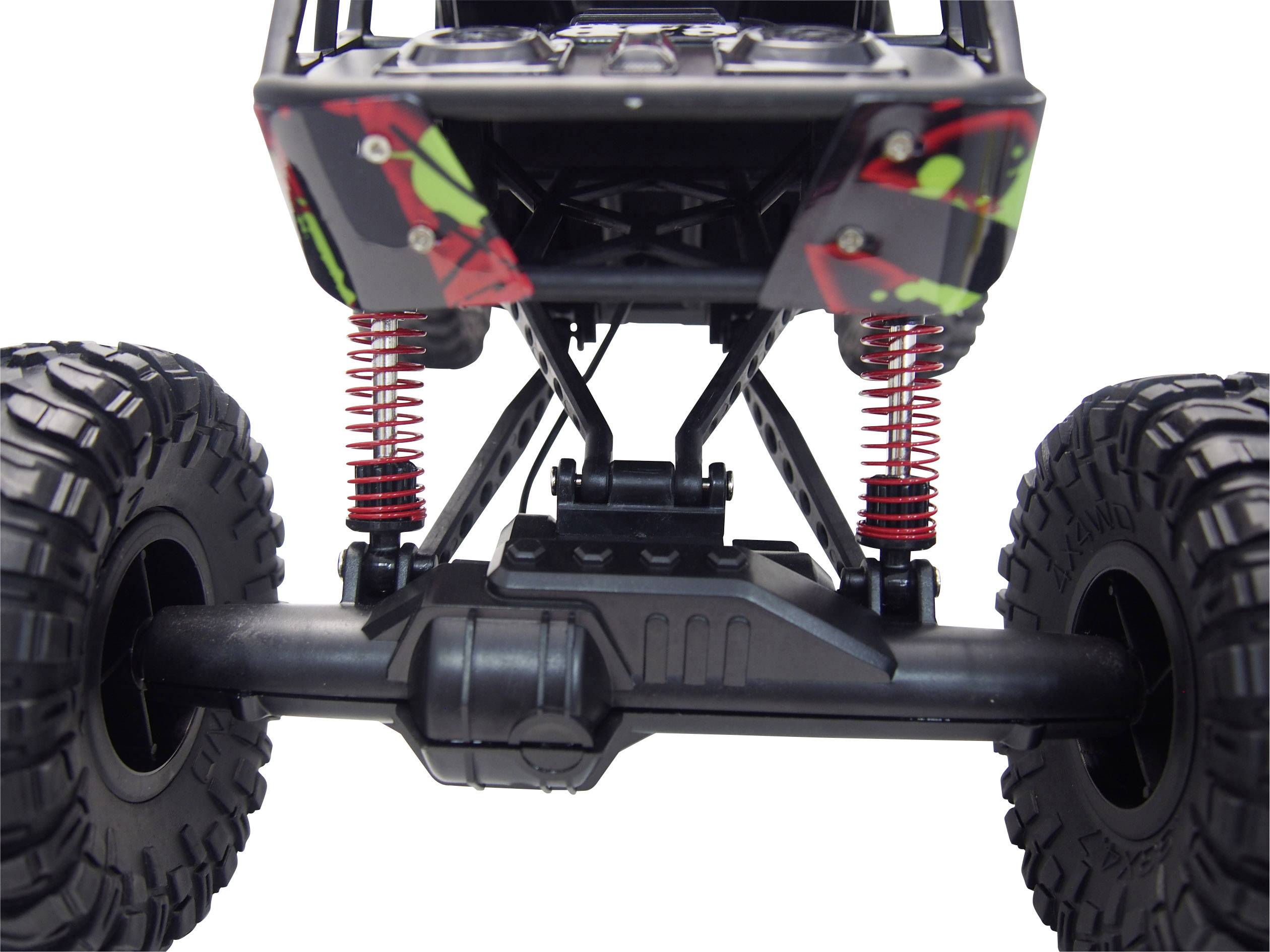 Close-up of the undercarriage of a remote-controlled car with large tyres and red springs.