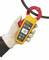 A hand is holding an electrical measuring device over a cable. The display shows a reading of 100.7. The device is yellow with red sensors.