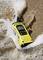 A yellow radio lies on the sandy beach, lapped by seawater.