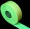 A roll of bright green, self-adhesive tape on a black background.