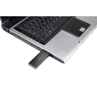 A black USB stick is plugged into the USB port of an open laptop. The laptop has a dark grey keyboard.