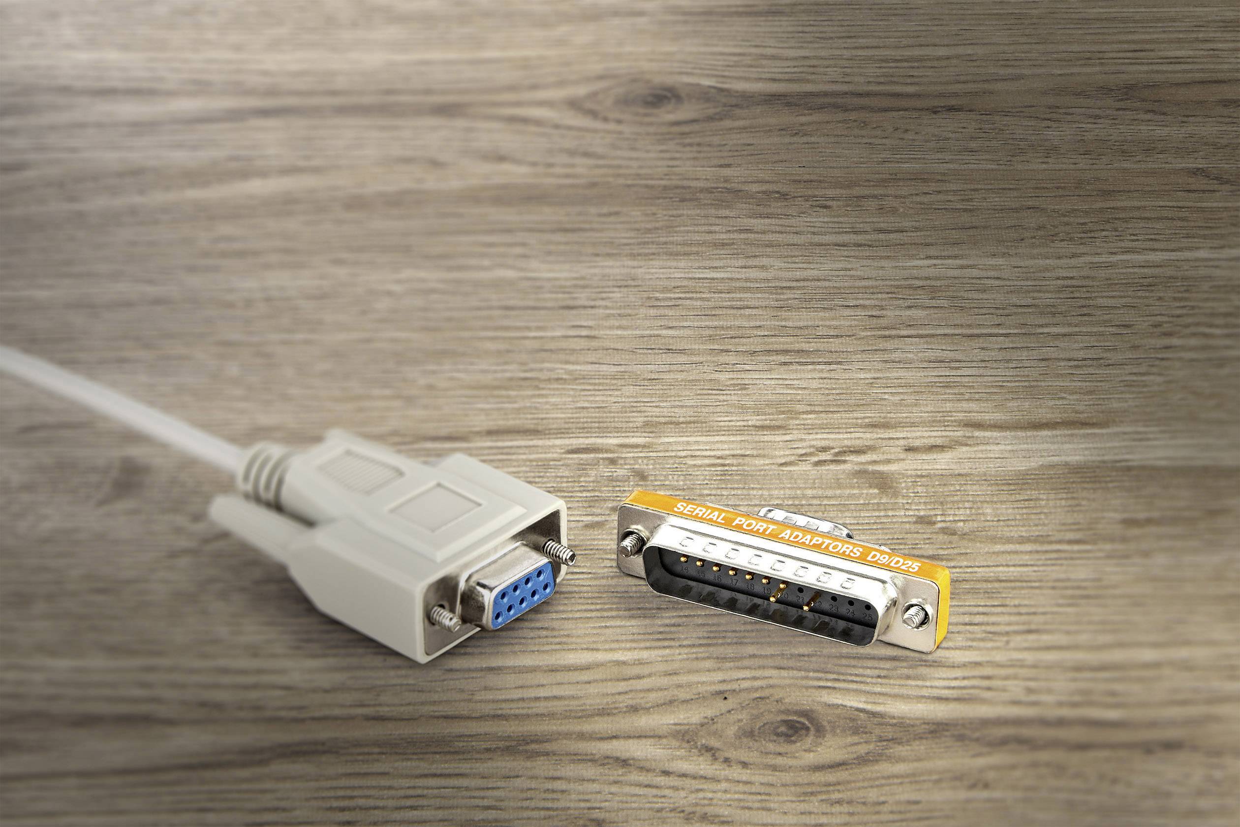 A serial cable with a VGA plug and an adapter labelled 'Serial Port Adapter DB-25', placed on a wooden table.