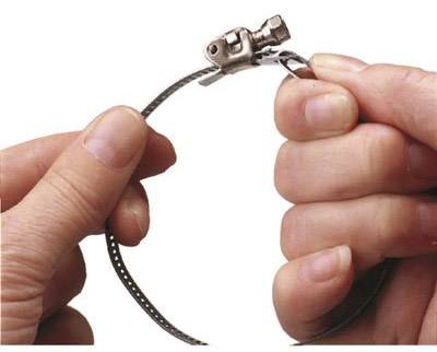 Two hands are holding a metal clamp. The left hand is pulling it tight, while the right hand prepares the screw for securing.